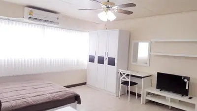 a bedroom with a bed and a desk and a television at Popular Condo C6 in Nonthaburi