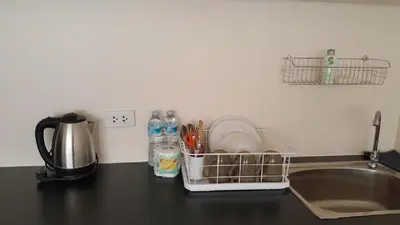 a kitchen counter with a sink and a dish drying rack at Popular Condo C6 in Nonthaburi