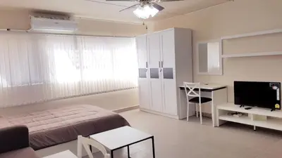 a bedroom with a bed and a desk and a television at Popular Condo P1 in Nonthaburi