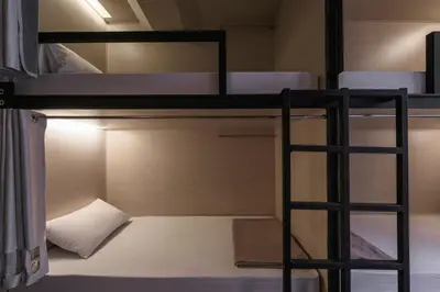 a bunk bed with a ladder in a room at ORA Hostel Bangkok in Bangkok