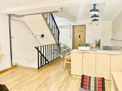 an open kitchen and living room with a staircase at ORA Hostel Bangkok in Bangkok