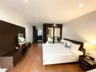 a bedroom with a large white bed in a room at 14 Place Sukhumvit Suites in Bangkok