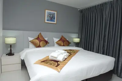 a bedroom with a white bed with towels on it at Top High Airport Link Hotel, Bangkok in Bangkok