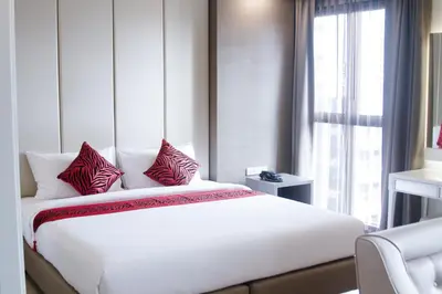 a bedroom with a large white bed with red pillows at Hope Land Hotel Sukhumvit 8 in Bangkok