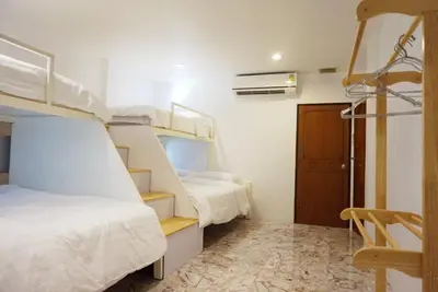 a room with two bunk beds and a staircase at Boon Street Hostel in Bangkok