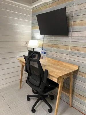 a desk with a chair and a television on a wall at La Locanda in Bangkok