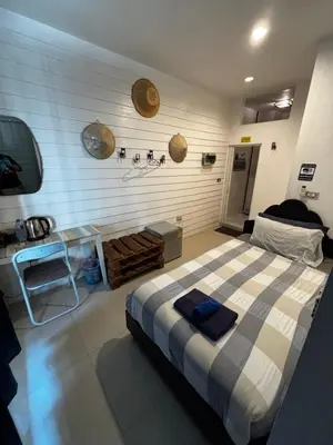 a bedroom with a bed and a table in it at La Locanda in Bangkok