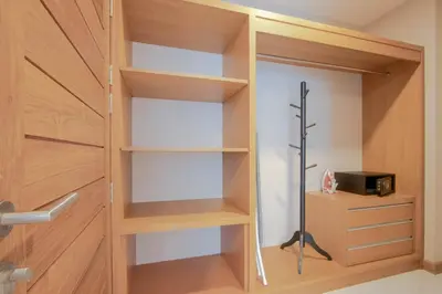 a closet with wooden shelves and a door at Kepler Residence Bangkok in Bangkok