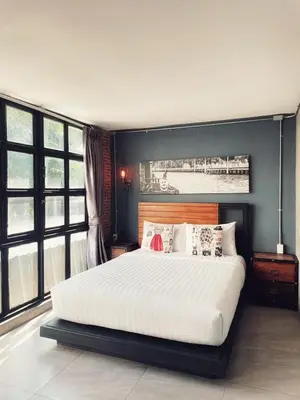 a bedroom with a large bed with white sheets and pillows at Yotaka The Hostel in Bangkok