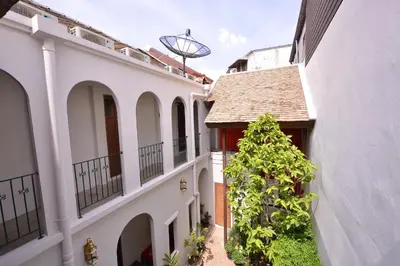 an empty courtyard of a house with a tree at Neighbor Phuthon in Bangkok