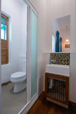 a bathroom with a toilet and a sink and a mirror at Neighbor Phuthon in Bangkok