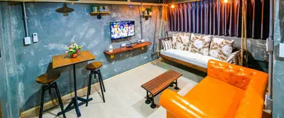 a living room with a couch and a tv at Adagio Bangkok in Bangkok