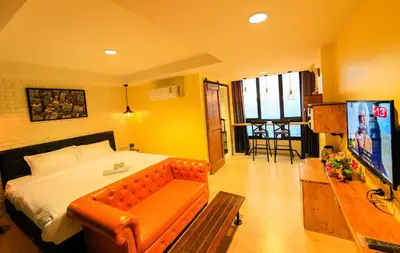 a bedroom with a bed with a couch and a tv at Adagio Bangkok in Bangkok