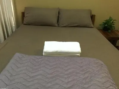 a bed with a white towel on top of it at Donmuang At Last in Bangkok