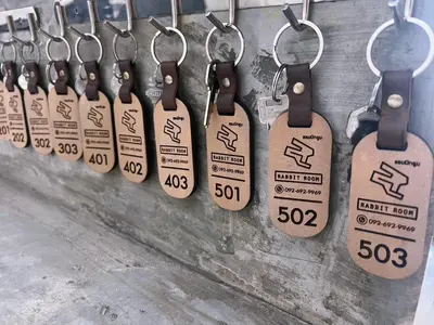 a row of keys and price tags hanging on a wall at Rabbit Room in Bangkok