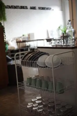 a shelf with dishes and plates on it in a kitchen at Krit Hostel in Bangkok