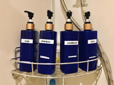 four blue bottles sitting on a rack at Kinnon Deluxe Hostel Coworking Cafe in Bangkok