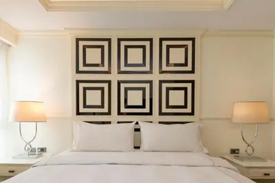 a bedroom with a white bed with two lamps at The LA49 Hotel in Bangkok