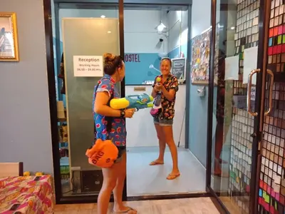 a woman standing in a store talking to a young girl at Zee Thai Hostel in Bangkok