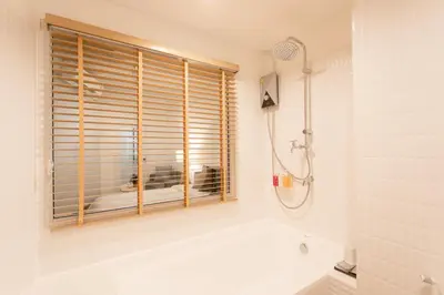 a bathroom with a tub and a window at Hotel PaPa Bangkok Siriraj in Bangkok