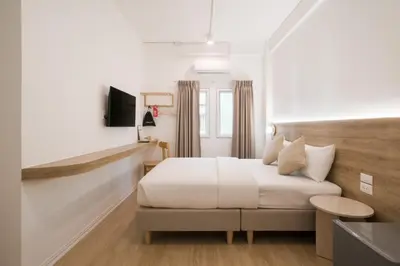 a hotel room with a bed and a tv at Hotel PaPa Bangkok Siriraj in Bangkok