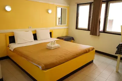a bedroom with a large yellow bed with two towels on it at Yes Kaosan in Bangkok