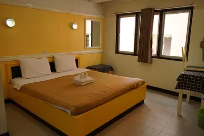 a bedroom with a bed with two towels on it at Yes Kaosan in Bangkok