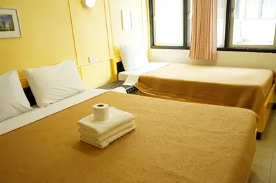 a hotel room with two beds with a roll of toilet paper at Yes Kaosan in Bangkok