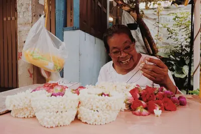a man is smiling next to a table with cakes at Theatre Residence in Bangkok