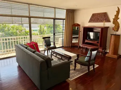 a living room with a couch and a piano at Samsen Suites Spacious 2BR Contemporary Thai Style in Bangkok