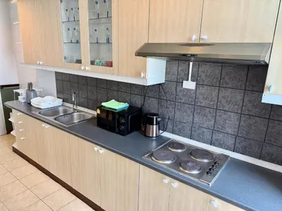 a kitchen with a sink and a stove top oven at Samsen Suites Spacious 2BR Contemporary Thai Style in Bangkok
