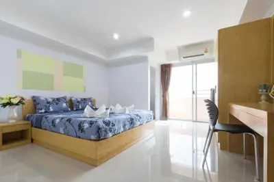 a bedroom with a bed and a large window at Jr Mansion On Nut Soi 25 in Bangkok