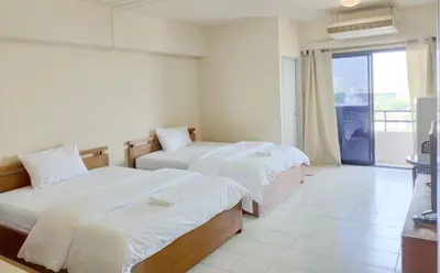 a hotel room with two beds and a window at Grand Residence Ngamwongwan 19 in Nonthaburi