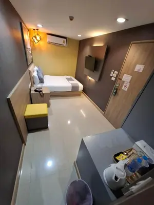 a small room with a bed and a desk at Collection O Pratunam 19 Hotel in Bangkok