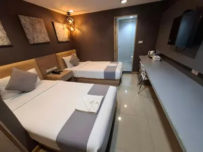 a hotel room with two beds and a television at Collection O Pratunam 19 Hotel in Bangkok