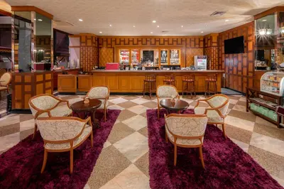 a room with tables and chairs and a bar at Alexander Hotel in Bangkok