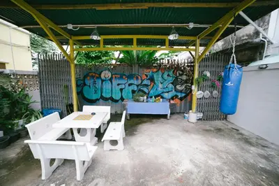a picnic shelter with a table and benches and graffiti at Diff Hostel in Bangkok