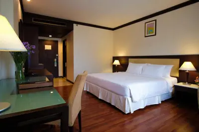 a hotel room with a bed and a desk and a bedroom at Zenith Sukhumvit Hotel, Bangkok in Bangkok