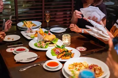 a group of people sitting around a table with plates of food at Zenith Sukhumvit Hotel, Bangkok in Bangkok