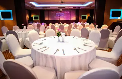 a set up for a banquet with white tables and chairs at Zenith Sukhumvit Hotel, Bangkok in Bangkok