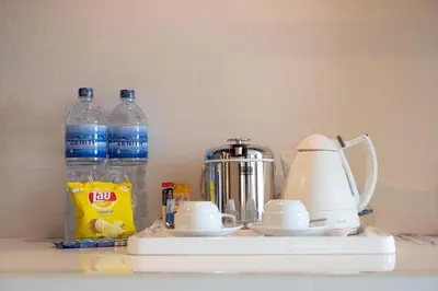 a counter with two bottles of water and a blender at Zenith Sukhumvit Hotel, Bangkok in Bangkok