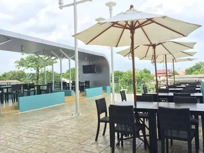 a restaurant with tables and chairs and umbrellas at Anna-Nava Pakkret Hotel in Nonthaburi