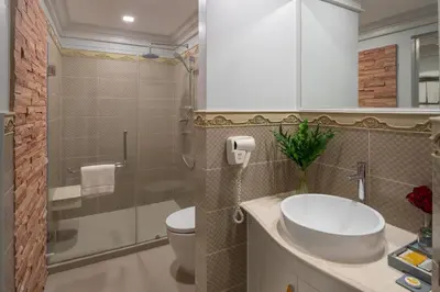a bathroom with a sink and a toilet and a shower at Kingston Suites Bangkok in Bangkok