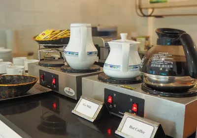 three white vases sitting on top of a counter at Kingston Suites Bangkok in Bangkok