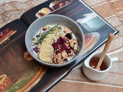 a bowl of food on a table with a cup of tea at Issara by D Hostel in Bangkok