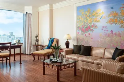 a living room with a couch and a table at The Emerald Hotel in Bangkok