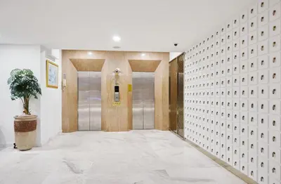 a hallway with two elevators in a building at Sunday Platinum Suites in Bangkok
