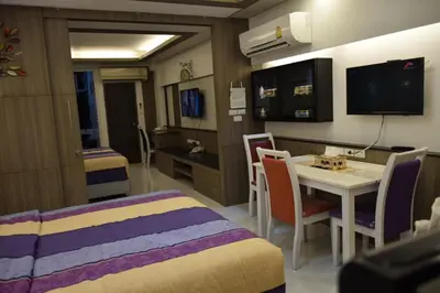 a room with a bed and a table and chairs at Family Suite Room Pratunam in Bangkok