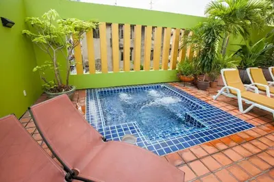 a small swimming pool on a patio with two chairs at The Aiyapura Bangkok in Bangkok