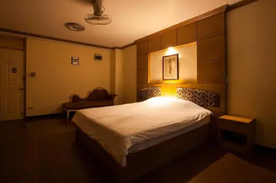 a bedroom with a bed and a chair in it at The Aiyapura Bangkok in Bangkok